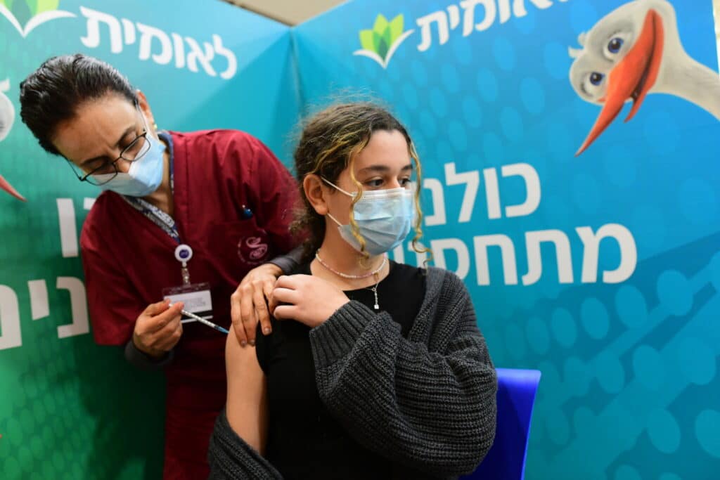 An Israeli student receives a Covid-19 vaccine injection, at Leumit Covid-19 vaccination center in Tel Aviv, on January 23, 2021. Photo by Avshalom Sassoni/Flash90 *** Local Caption *** ðâã ðâéó ä÷åøåðä àøðä ÷åøåðä çéñåï îåøä çéðåê ìàåîéú úìîéãéí àæøçéí çéñåðéí
