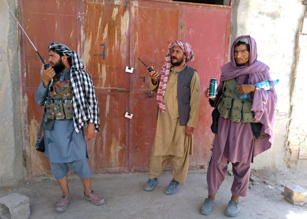 Taliban fighters stand guard at a checkpoint inside the city of Farah, capital of Farah province, southwest Afghanistan,