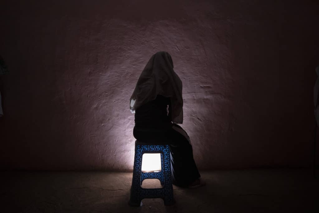 a Tigrayan refugee rape victim who fled the conflict in Ethiopia's Tigray sits for a portrait