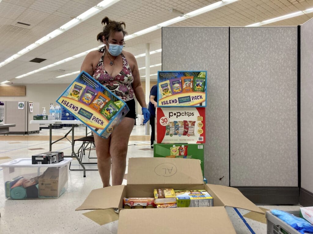 December Snedecor, a homeless woman who lives in a tent in Portland, Ore., helps set up snacks at a cooling center