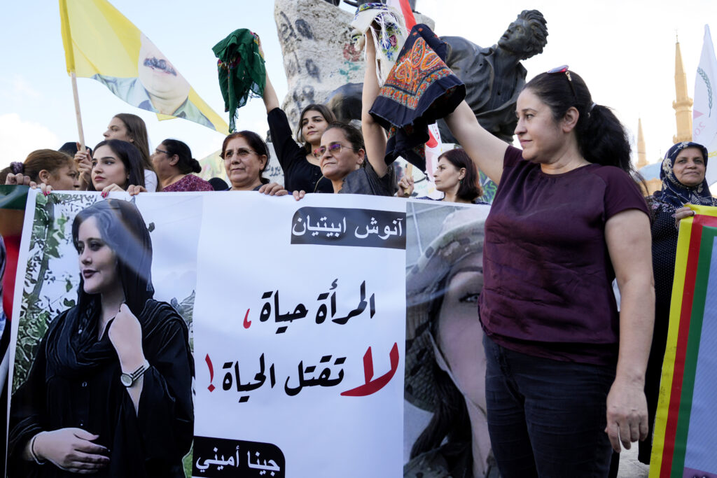 FILE – Kurdish women activists hold headscarfs and a portrait of Iranian woman Mahsa Amini, with Arabic that reads, “The woman is life, don’t kill the life,” during a protest against her death in Iran, at Martyrs’ Square in downtown Beirut, Sept. 21, 2022. The U.S. government has imposed sanctions on Iran’s morality police after the death in custody of a woman who’d been accused of wearing her Islamic headgear too loosely. (AP Photo/Bilal Hussein, File)